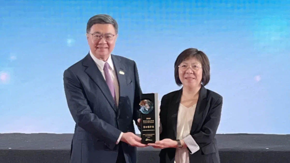 Dr. Mei-Chun Yang and Premier Cho Jung-tai on stage, holding the award trophy between them and facing the audience.